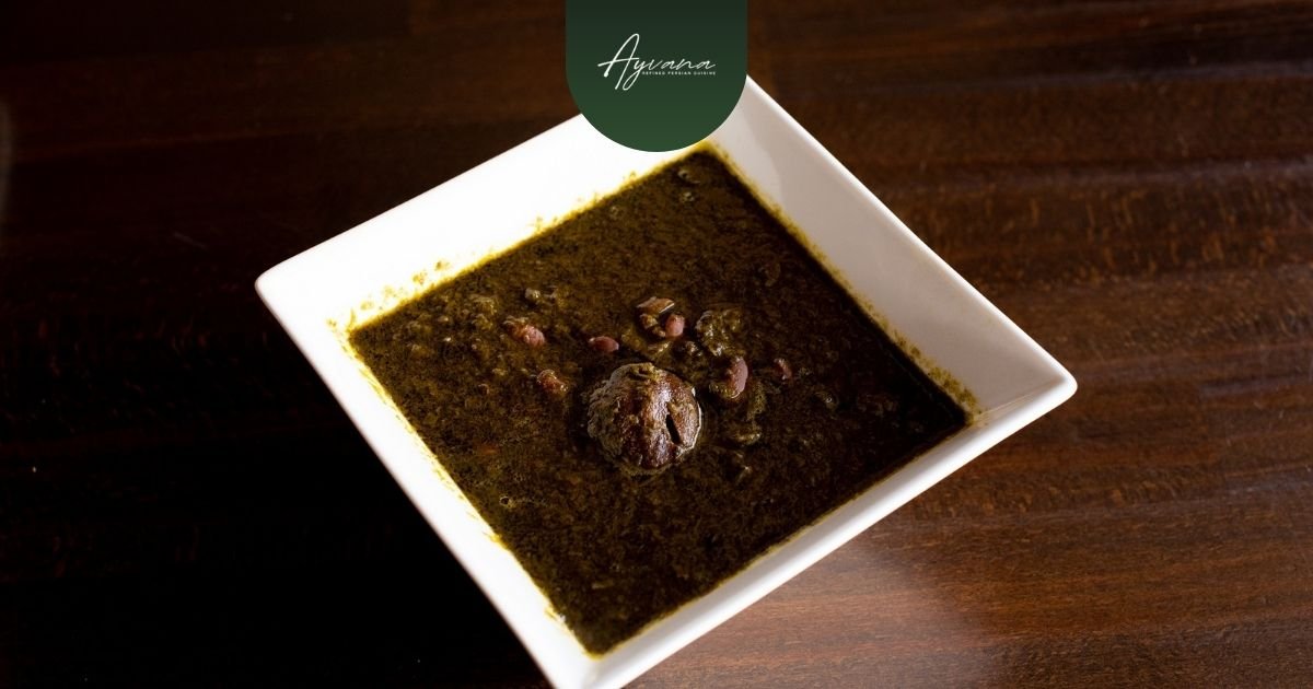 Close-up of hearty Ghormeh Sabzi Persian herb stew with tender meat and beans in a white square bowl at Ayvana.