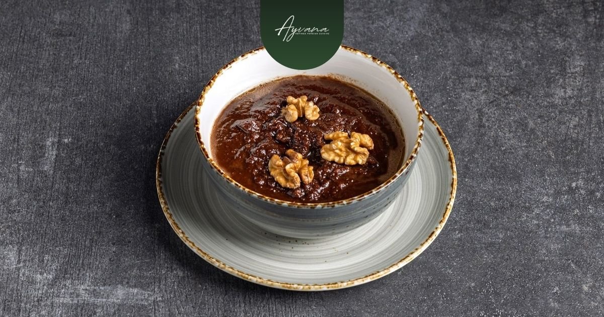Bowl of rich Persian Fesenjan stew topped with walnuts, featuring sweet tangy pomegranate flavors on dark table backdrop