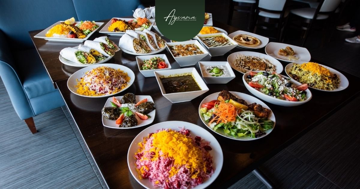 Traditional Persian cuisine dishes served family-style, featuring saffron rice, grilled kebabs, herbs, wraps, stews, and appetizers together.