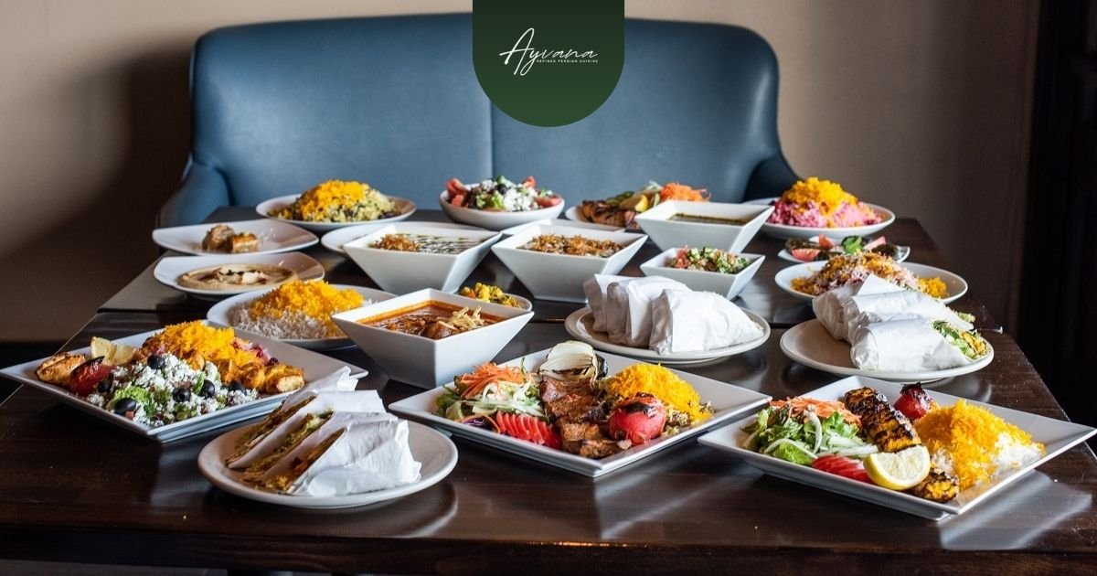 Colorful assortment of traditional Persian dishes including saffron rice, kebabs, salads, stews, and wraps on a restaurant table.